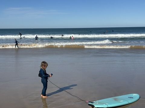 Young Ocean Club member carrying her surfboard